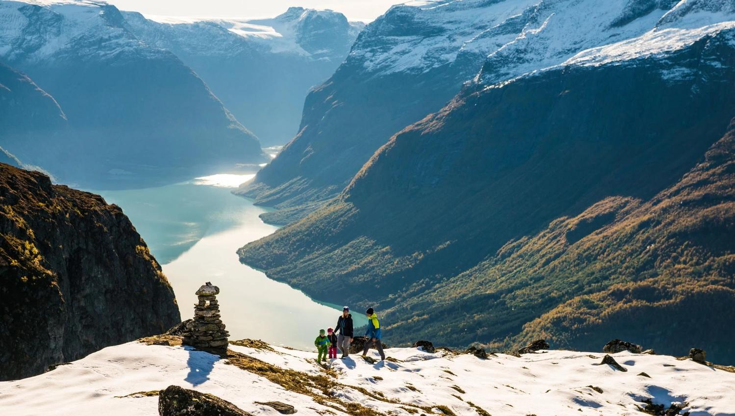 Hikers walking through the high mountain landscape at Hoven, with snow-covered peaks in the distance.