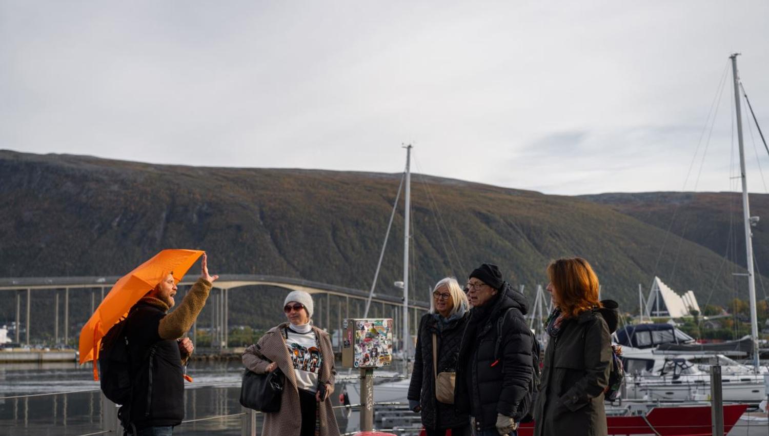Guests learn about Tromsø with the mountains behind