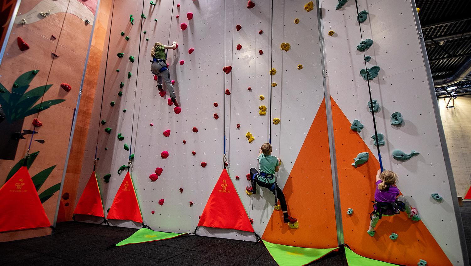 Children climb the climbing wall