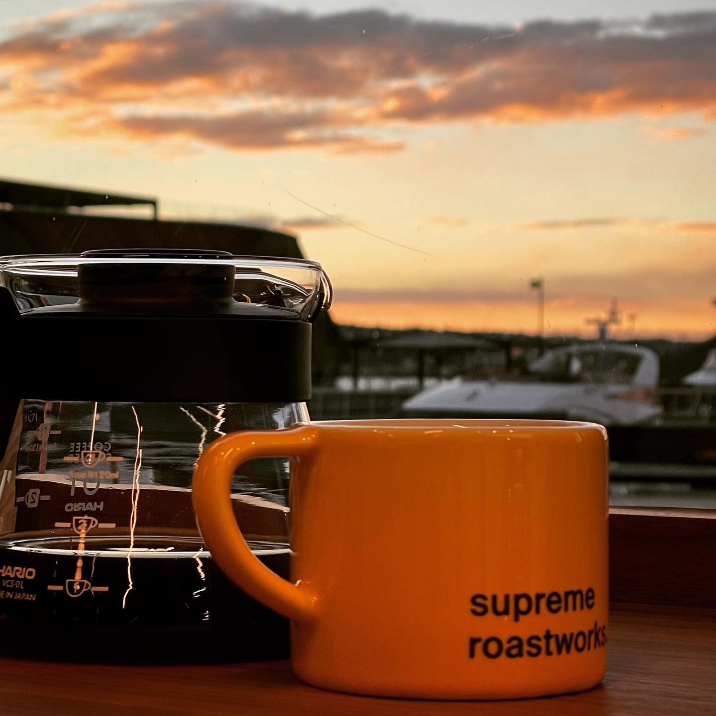 a cup from supreme roastwork and a coffee pot with a view of aker brygge