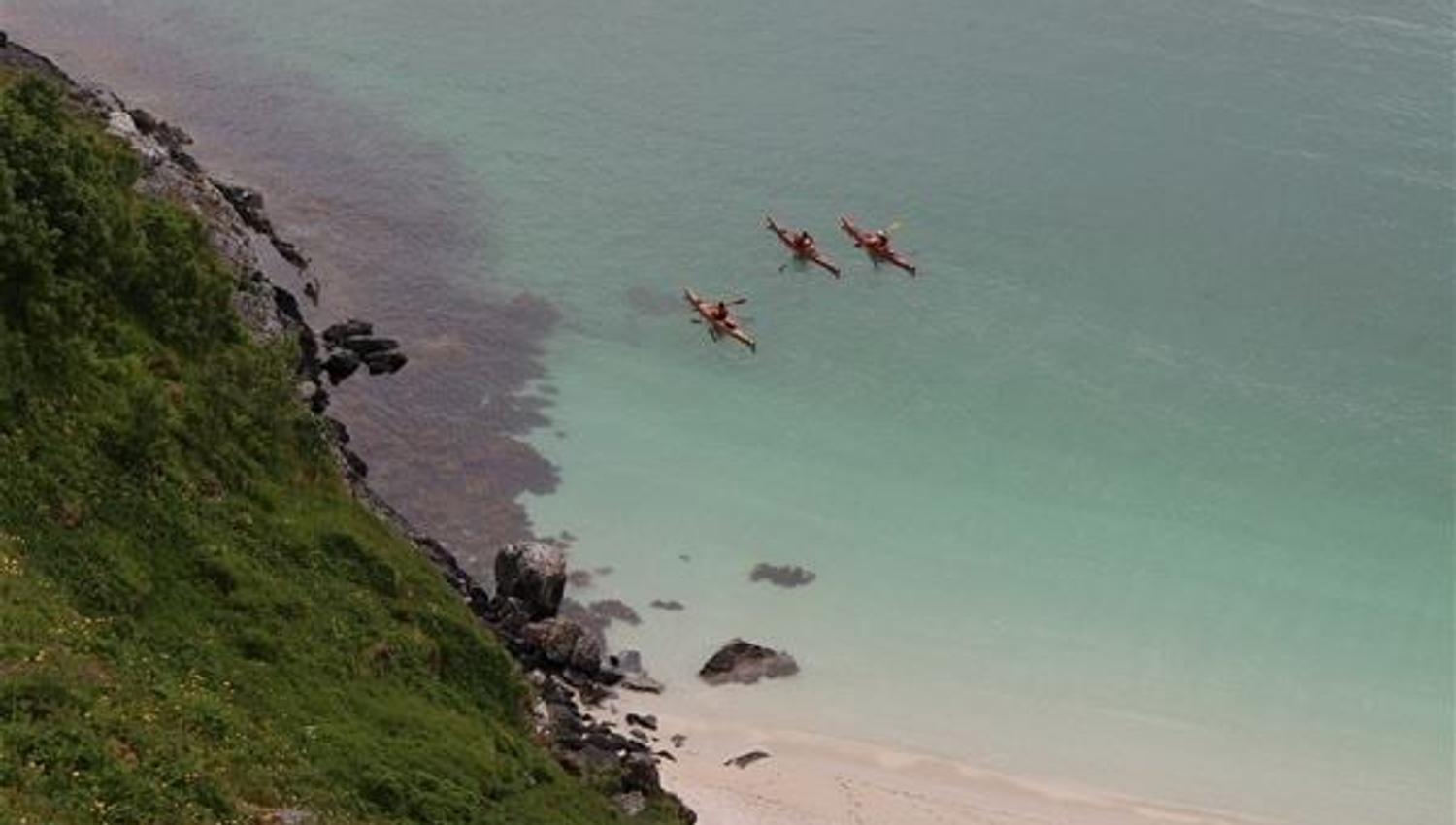 Three kayaks close to the shore