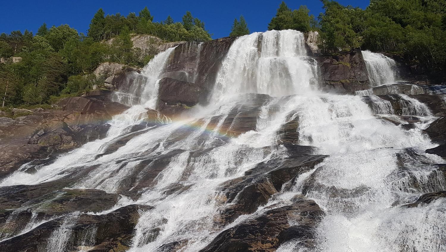 Close-up of Furubergsfossen – The powerful flow of Furubergsfossen highlighted, with a beautiful rainbow shimmer in the water.