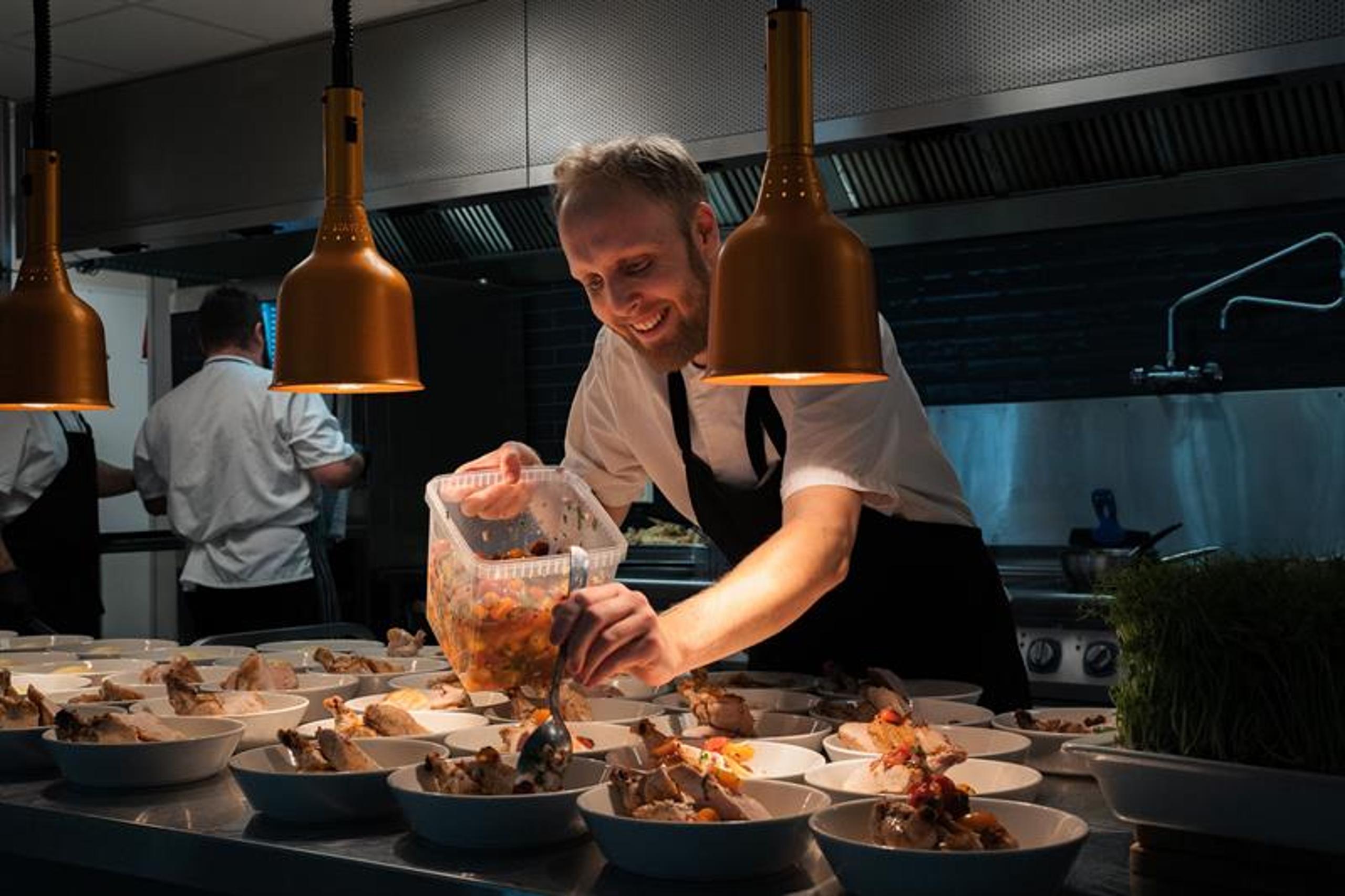 Chef puts food on plates 