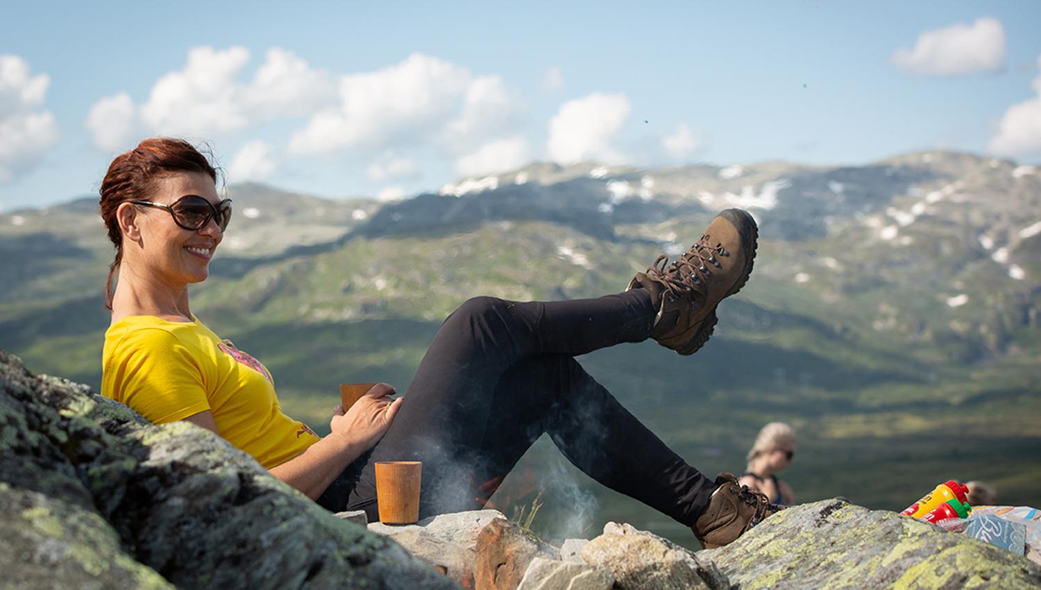 lady sitting on the mountain and enjoying a coffee