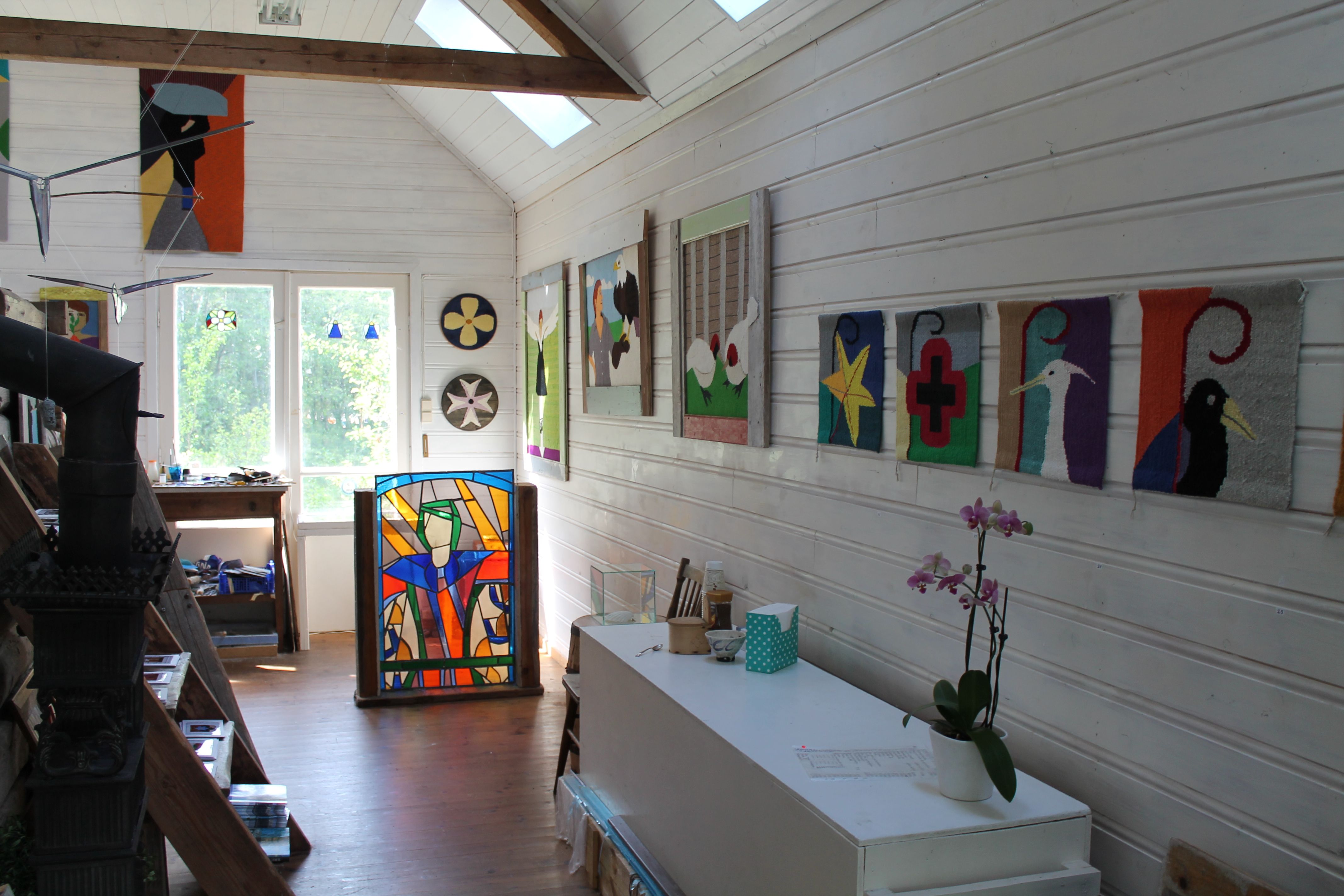 Viele verschiedene Kunstwerke an den Wänden und ein Glas-Kunstwerk auf dem Boden