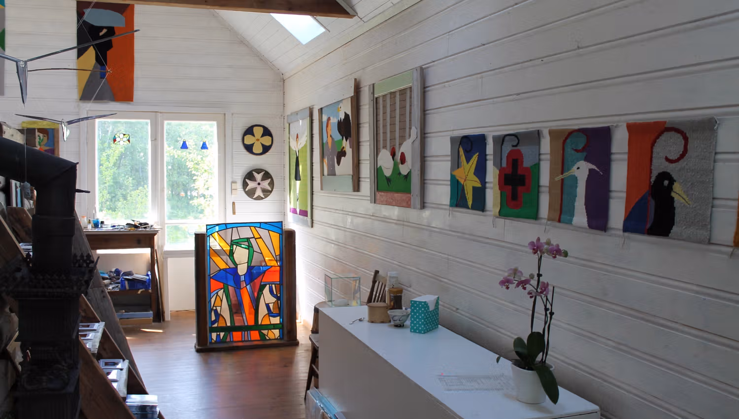 Viele verschiedene Kunstwerke an den Wänden und ein Glas-Kunstwerk auf dem Boden