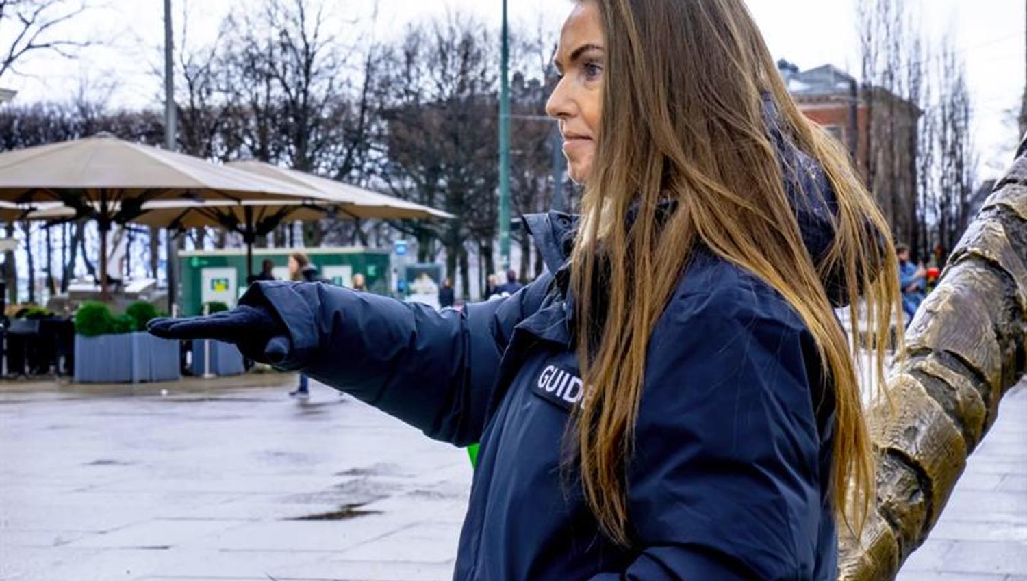 Female guide talking in front of The Tiger statue on Jernbanetorget