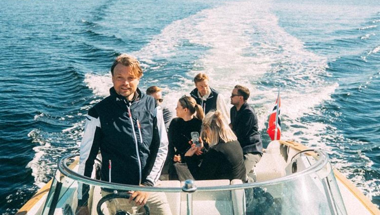 Kaptein og gjester ombord i båten på fjorden
