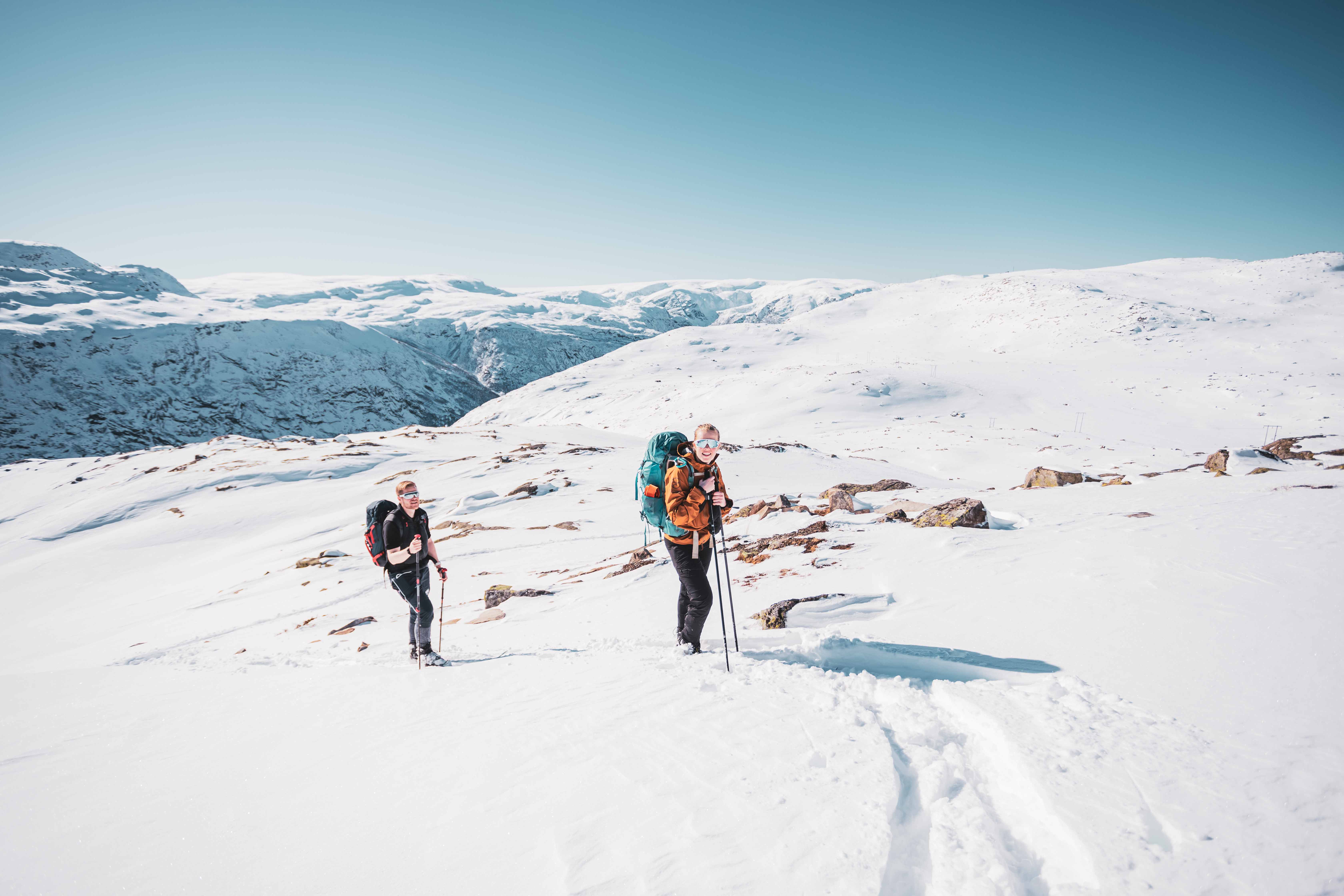 Two participants on a winter hike with backpacks and snowshoes near Trolltunga.