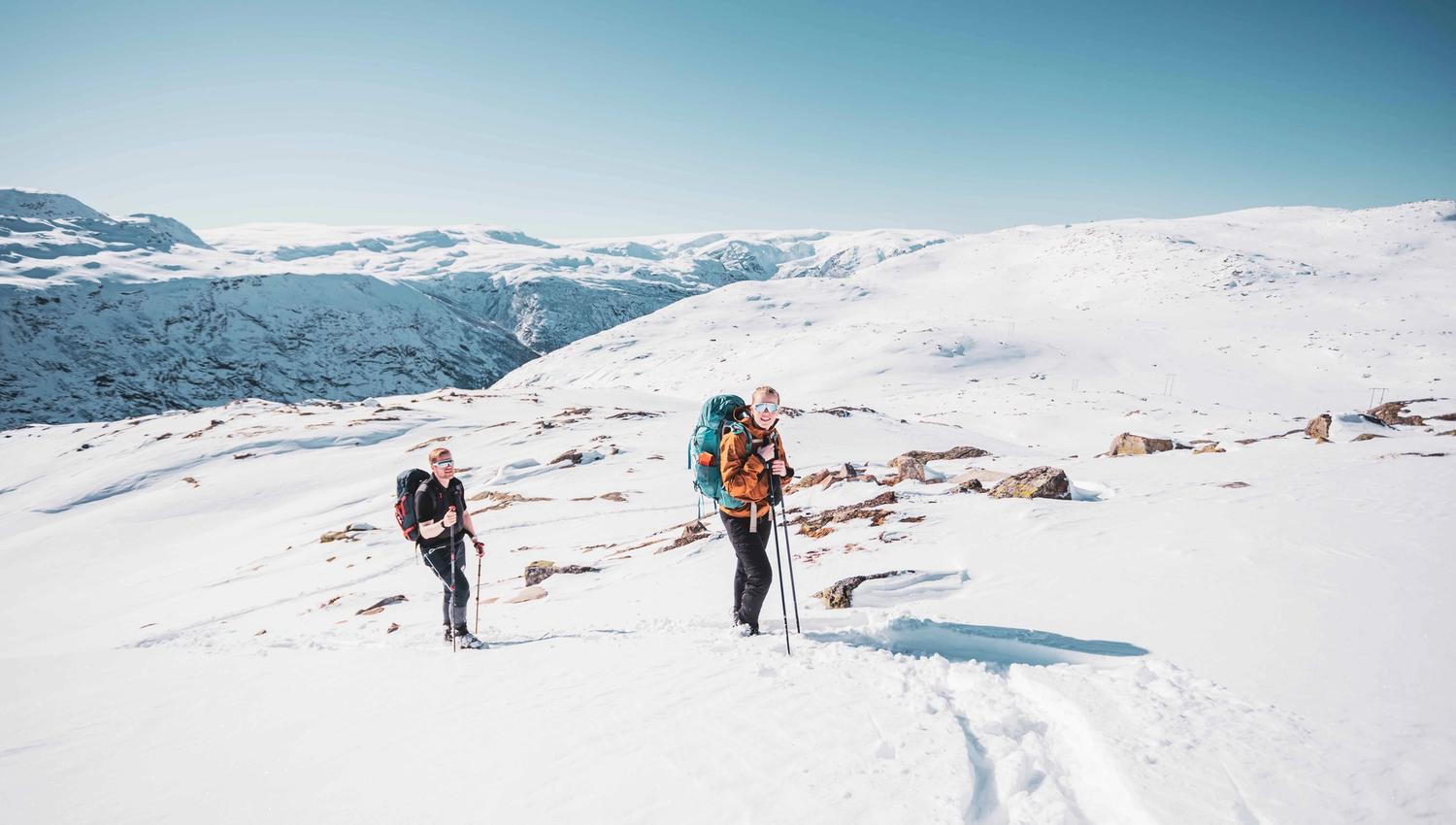 Two participants on a winter hike with backpacks and snowshoes near Trolltunga.