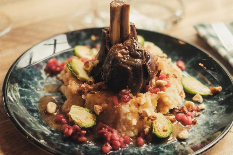 Kjøttrett servert med puré og grønnsaker på en restaurant