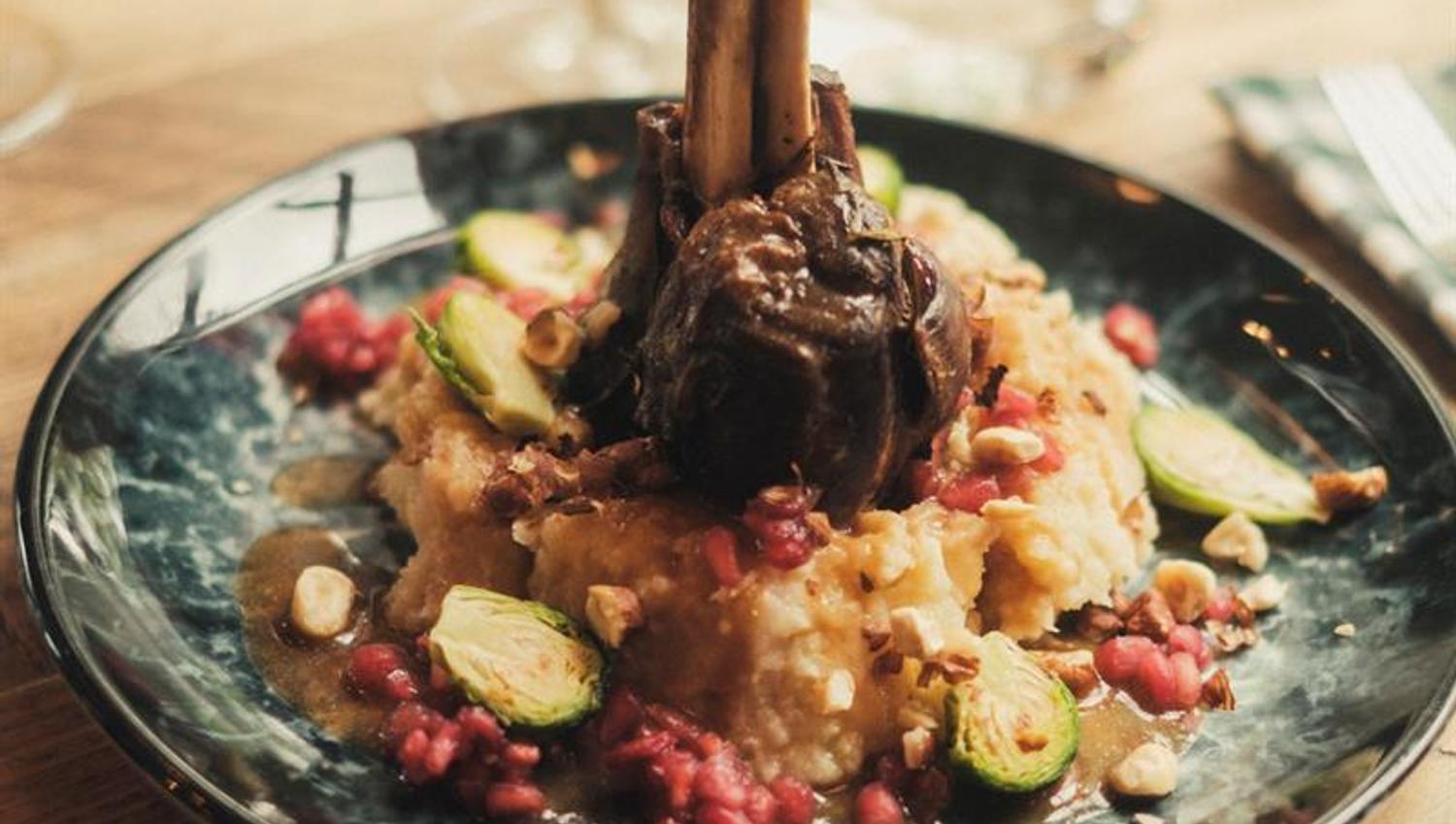 Kjøttrett servert med puré og grønnsaker på en restaurant