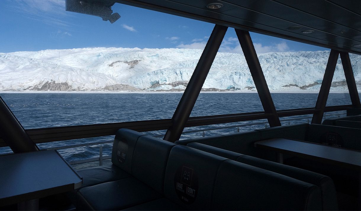 View towards a glacier and a fjord through the boat MS Bard's panoramic windows