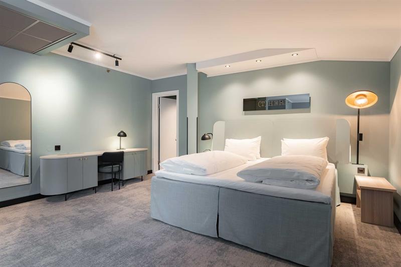 Junior suite with double bed and blue-green walls