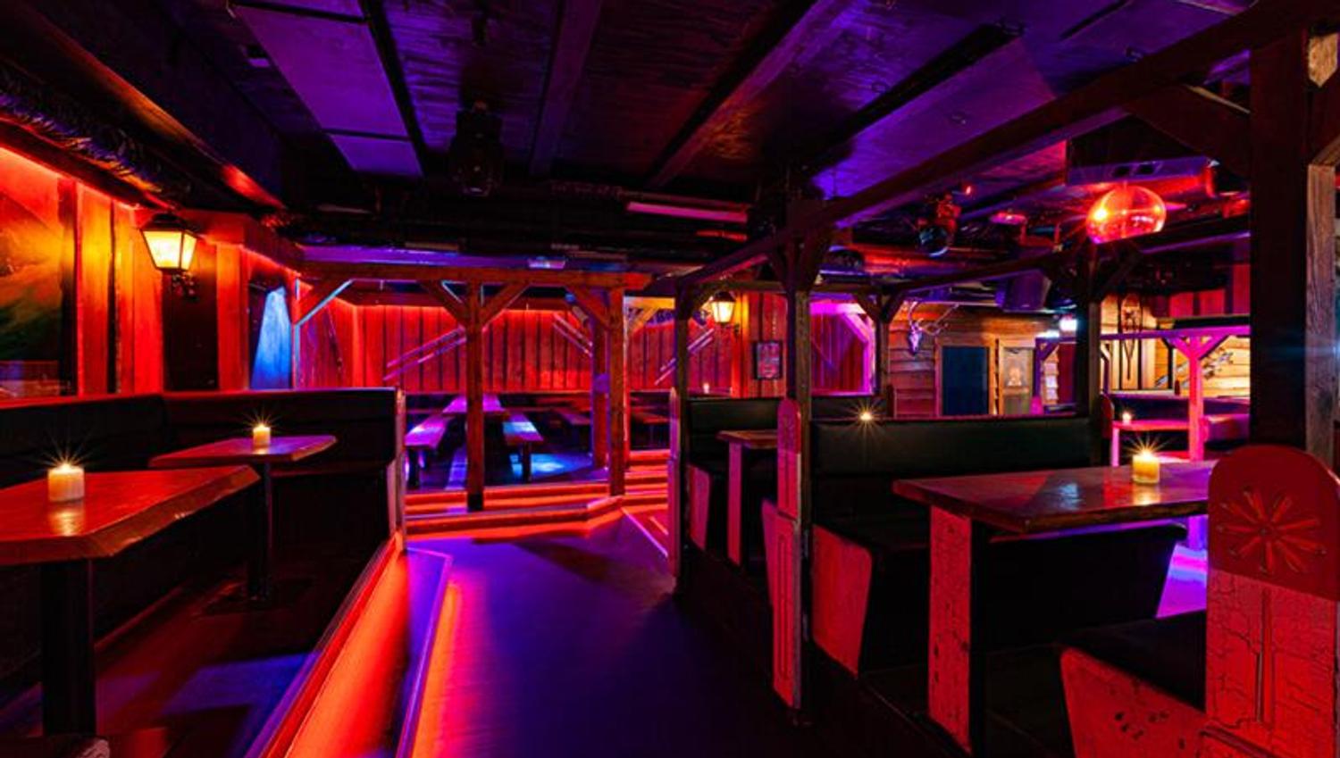 Bar interior with seating booths surrounded by neon lights