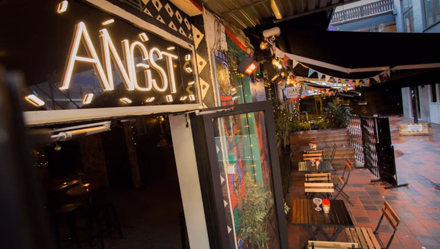 Exterior of bar sign, as well as the outdoor seating.