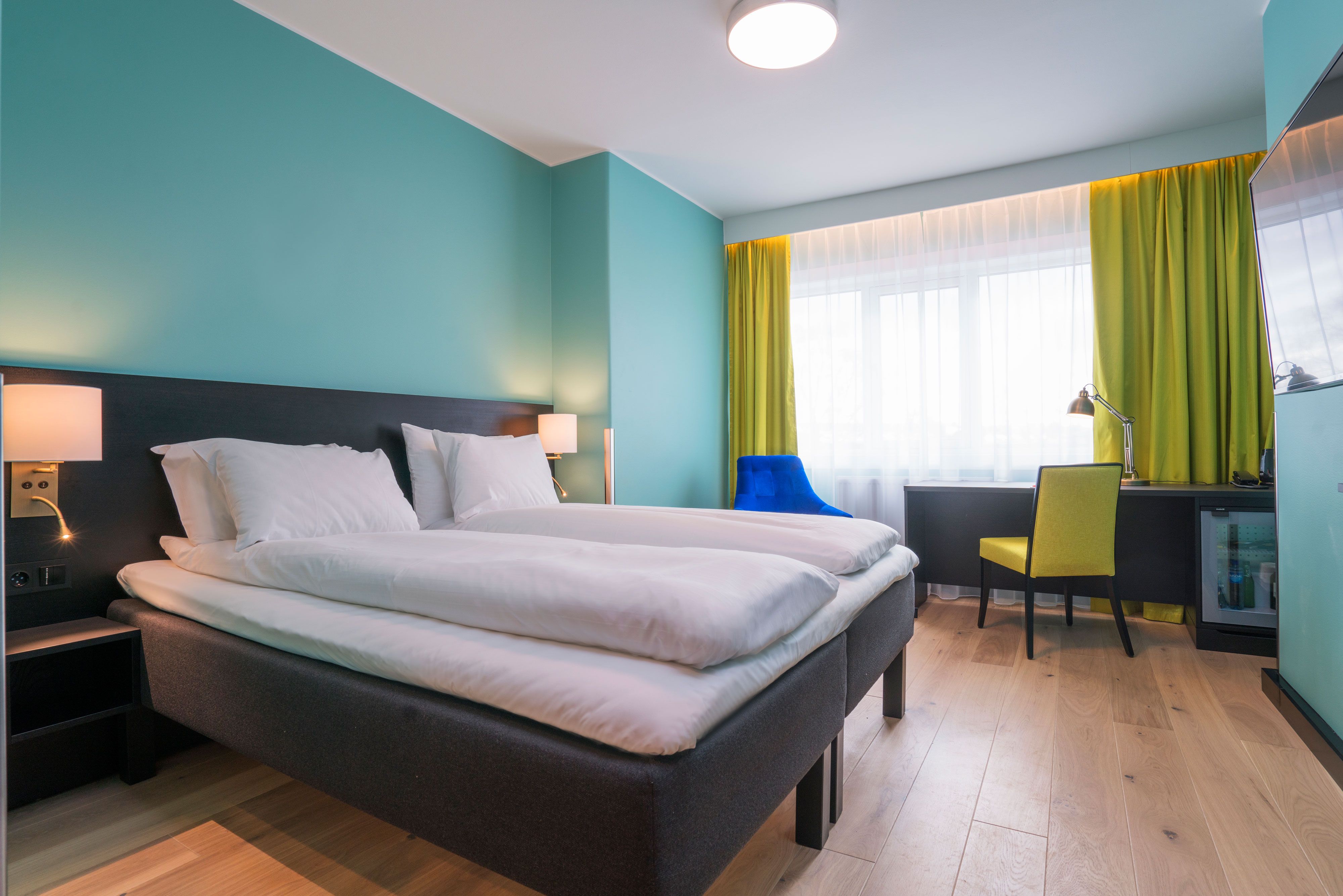 Colorful twin room with bed and desk