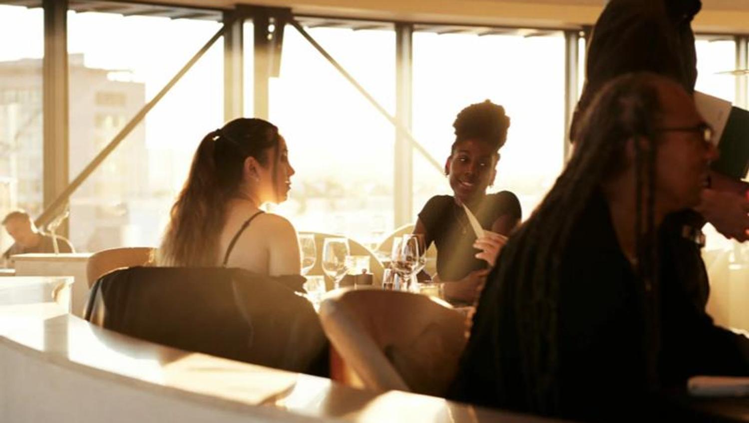 People eating while the sun shines through the window.