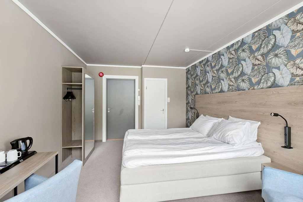 Comfortable double room at Kinsarvik Fjordhotel with modern decor and views of the natural surroundings.