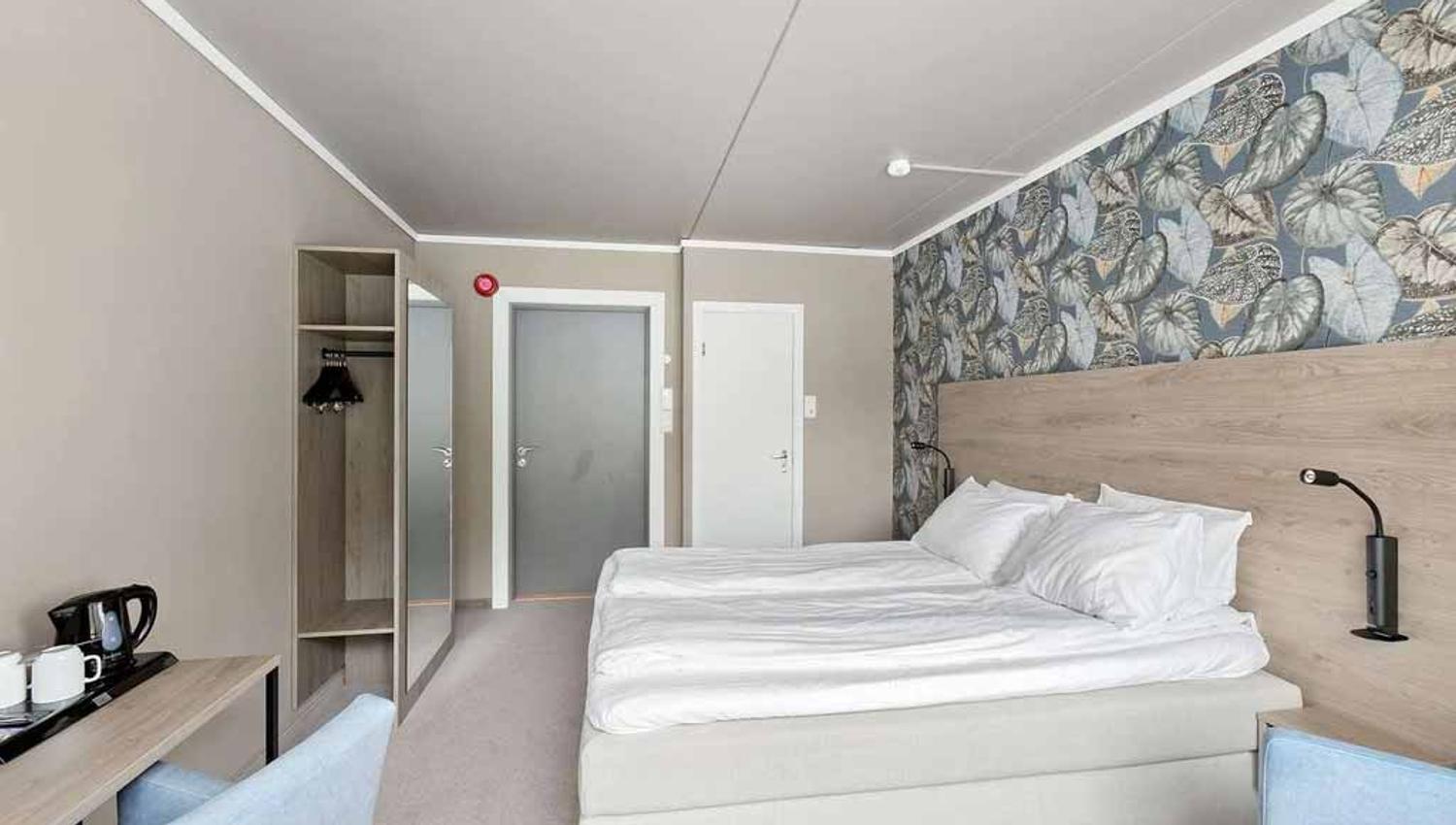 Comfortable double room at Kinsarvik Fjordhotel with modern decor and views of the natural surroundings.