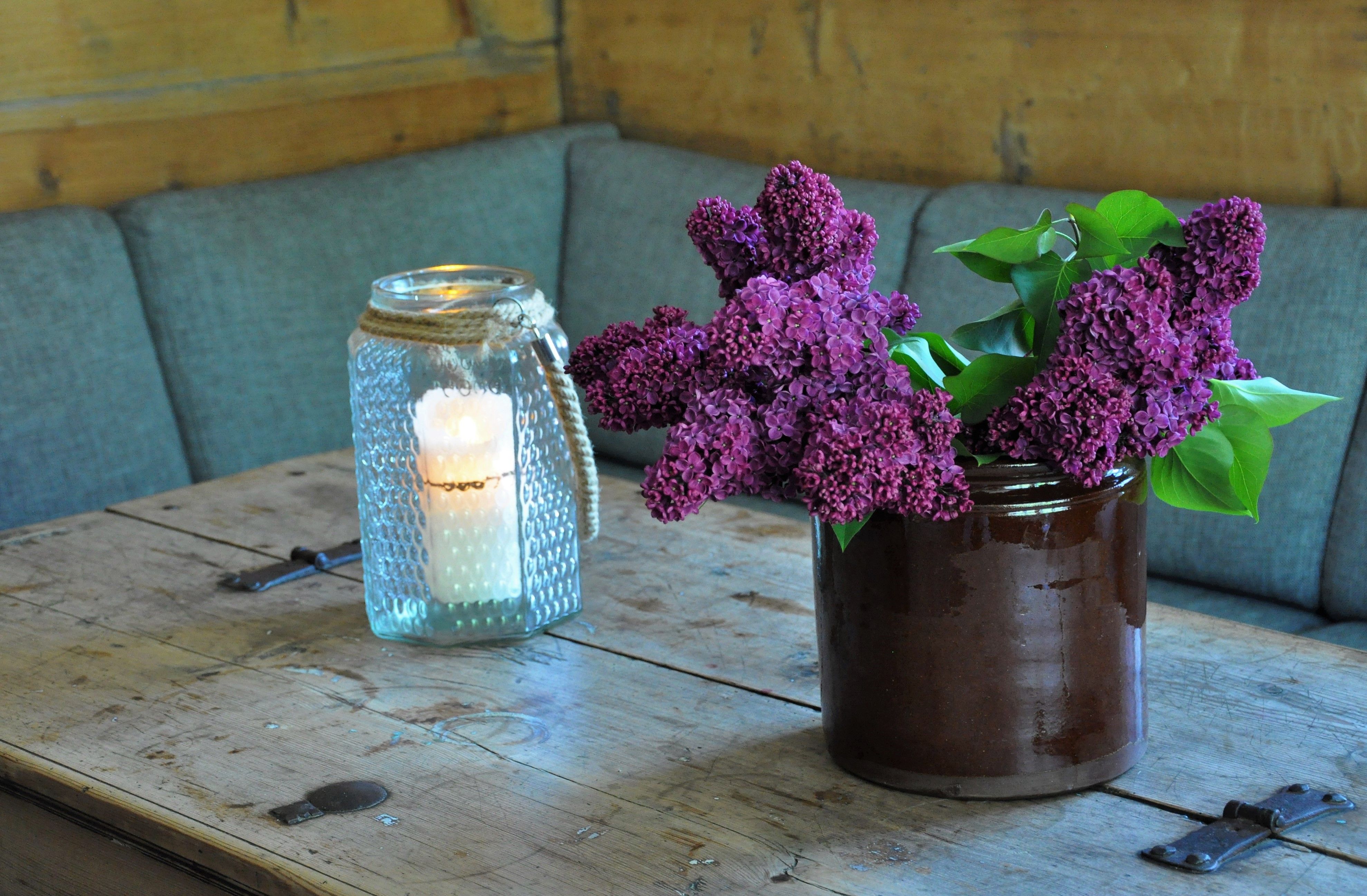 A sofa by a table with flowers and a candle 