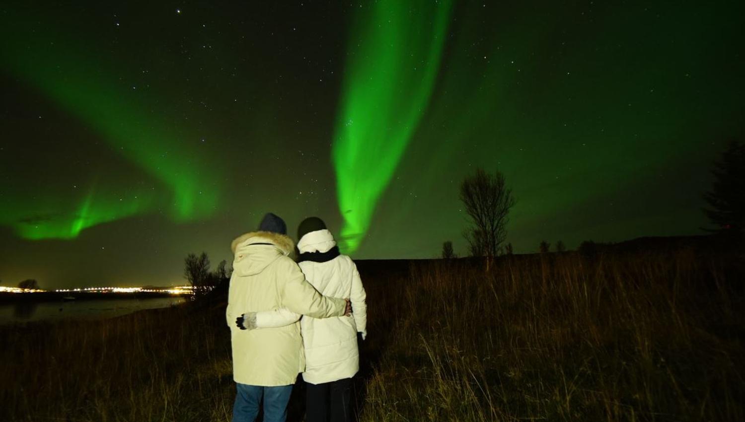 Two people watching the northern lights