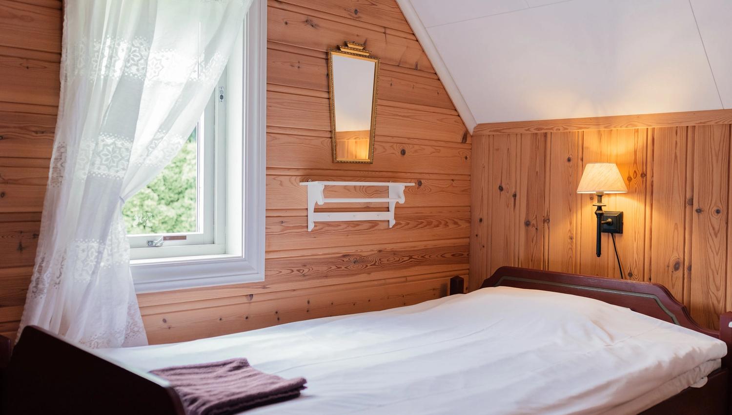 Traditional wooden bedroom at Stana Farm – nostalgic atmosphere and peaceful fjord ambience.