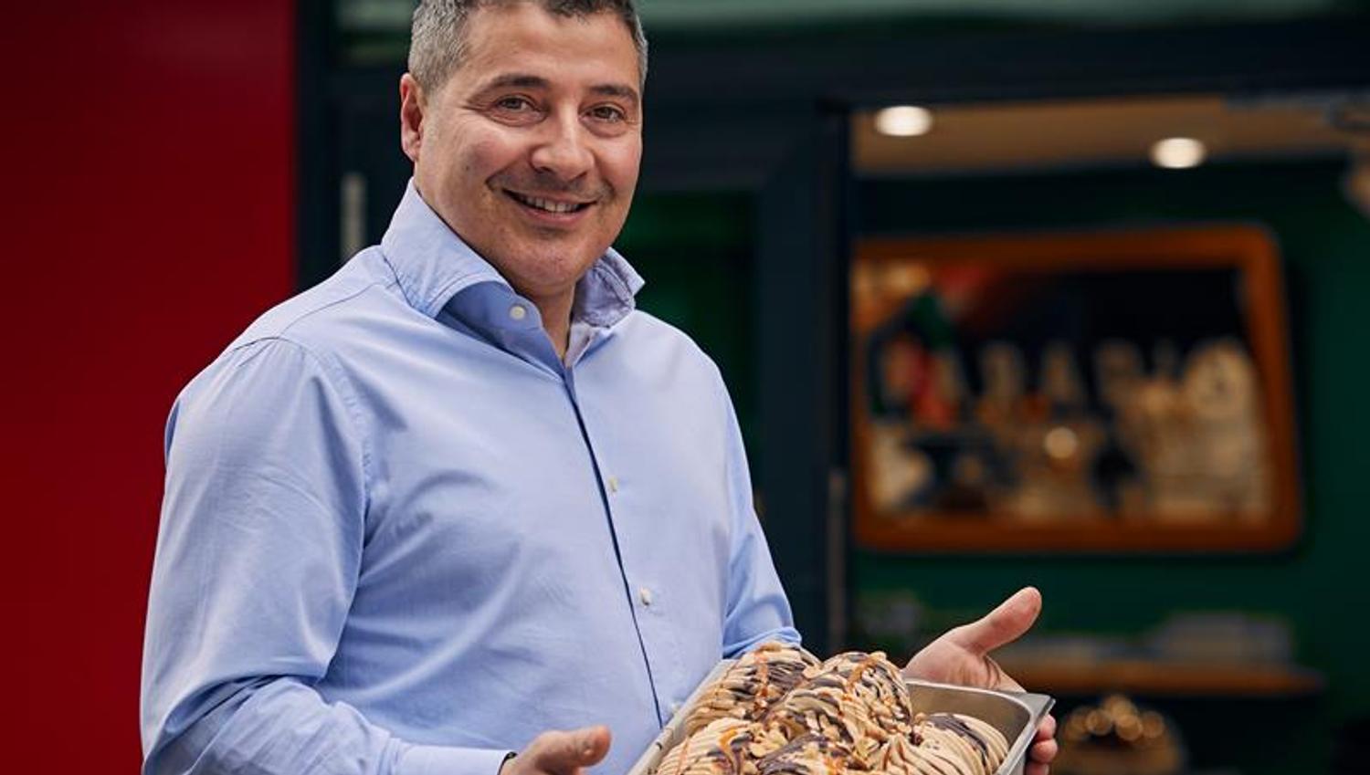 Mann som poserer med iskrem foran kaféen