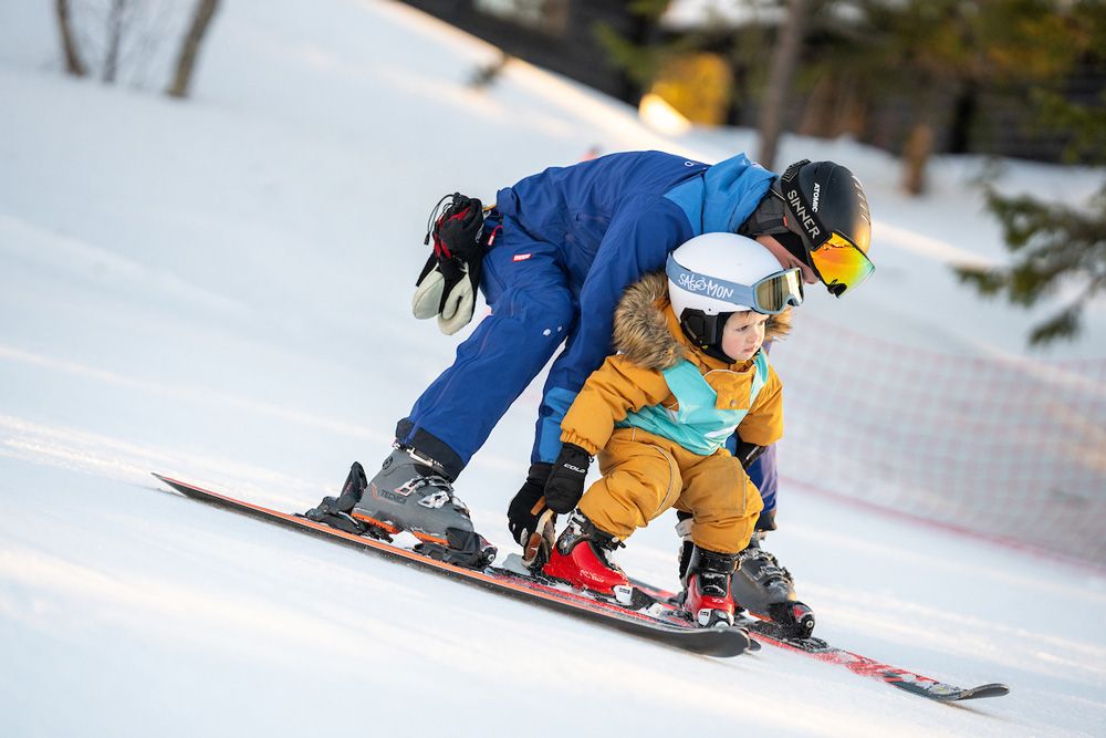 father teaches children to ski
