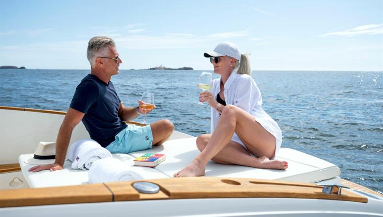 Mann og knvinne ombord i båten som skåler