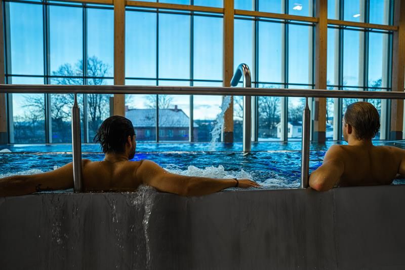 To personer i boblebad med store panoramavinduer i bakgrunnen