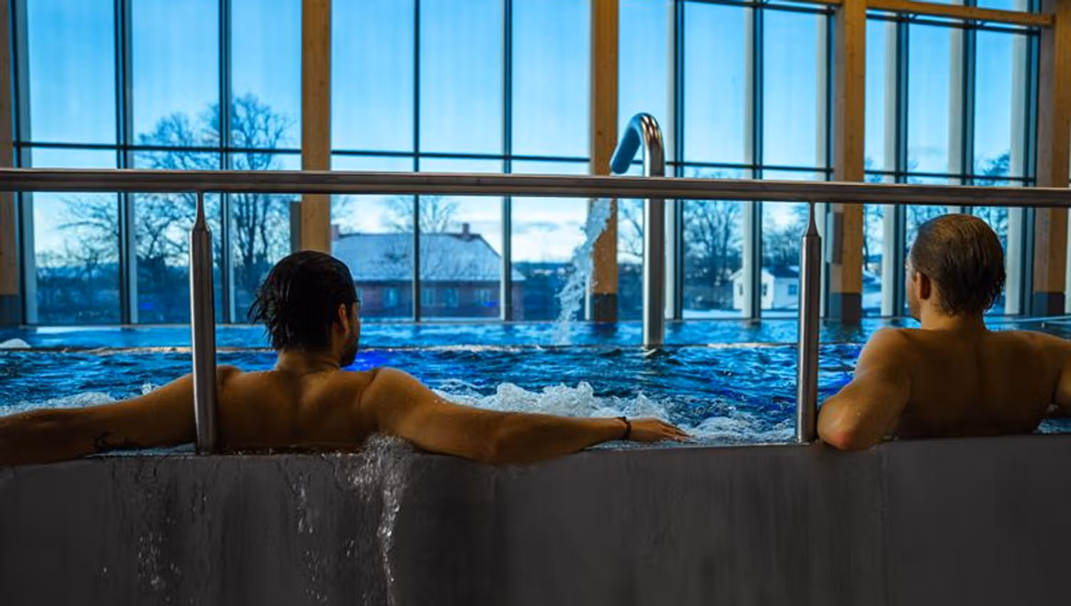 To personer i boblebad med store panoramavinduer i bakgrunnen