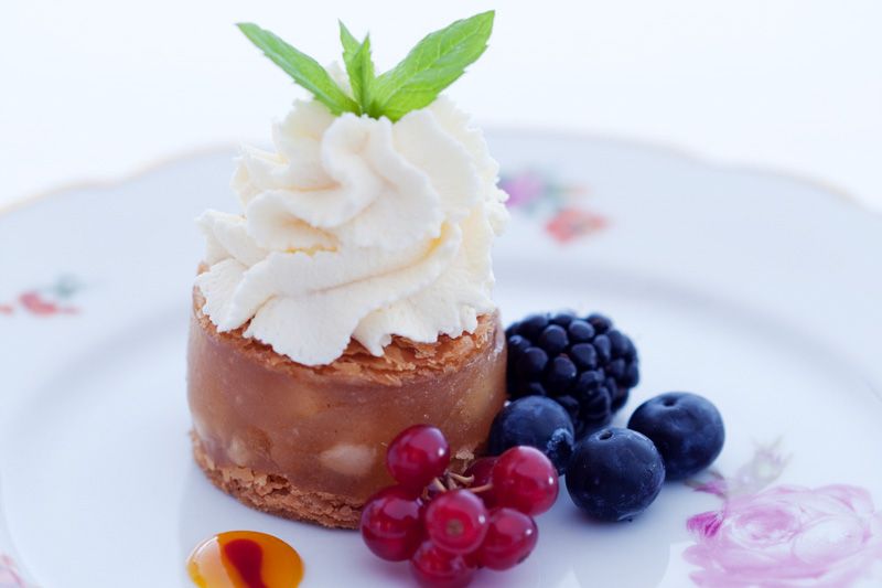 Detaljbilde av dessert på en hvit tallerken med blomster på.