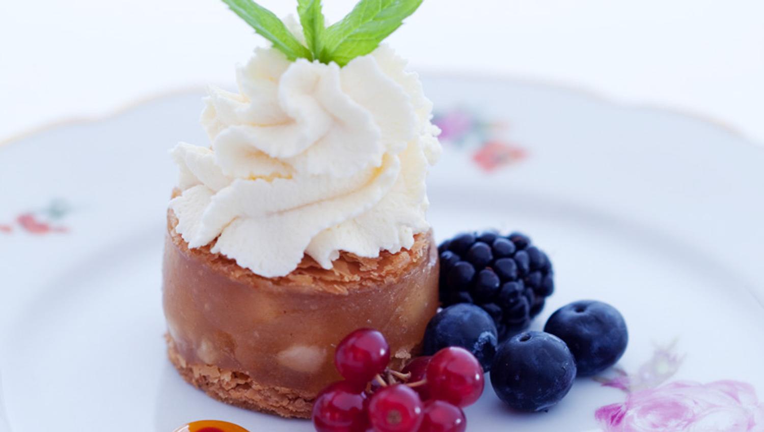 Detaljbilde av dessert på en hvit tallerken med blomster på.