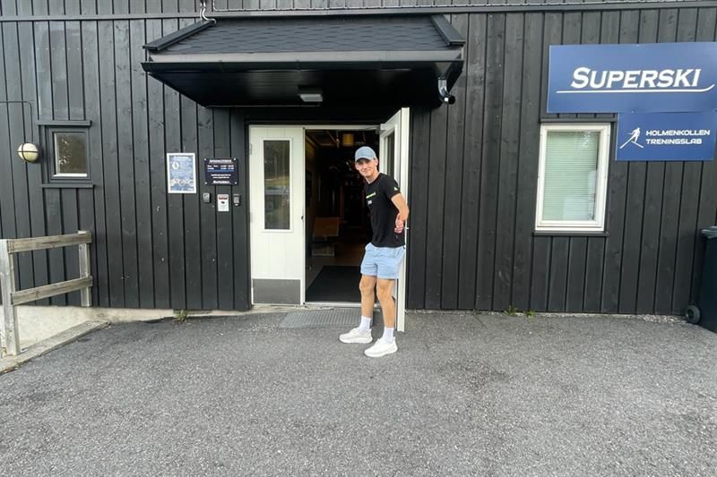 Butikkeksteriør med mann som holder døren åpen.
