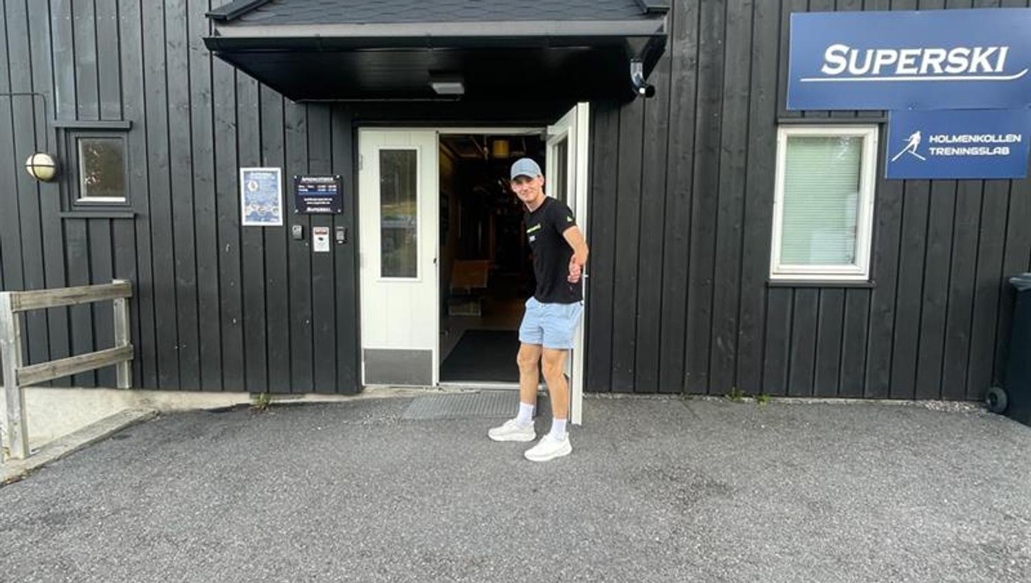 Butikkeksteriør med mann som holder døren åpen.