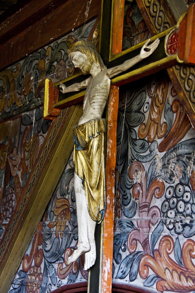 Wooden sculpture of Christ on the cross in Røldal Stave Church, symbolizing its long pilgrimage history.