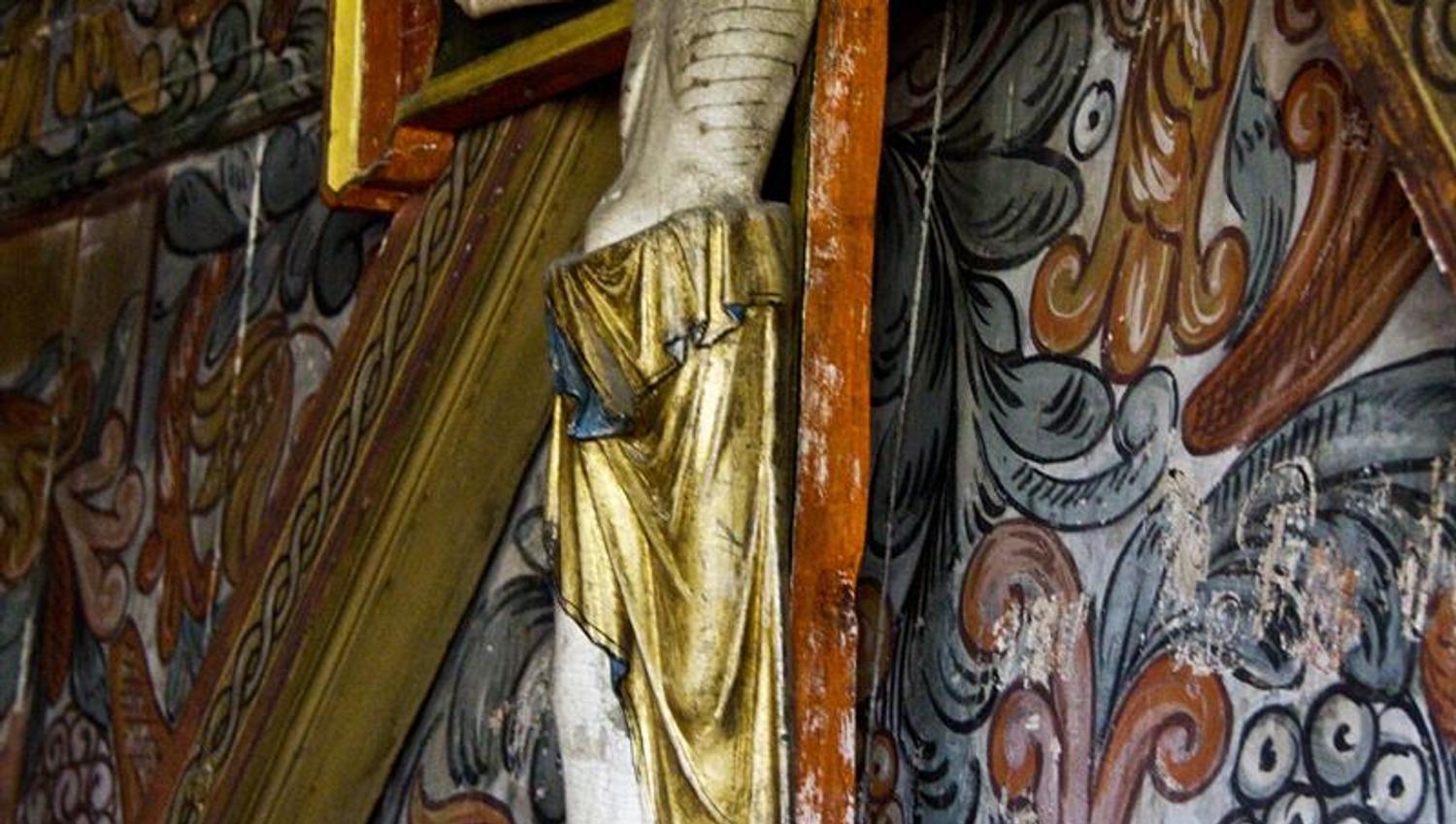 Wooden sculpture of Christ on the cross in Røldal Stave Church, symbolizing its long pilgrimage history.