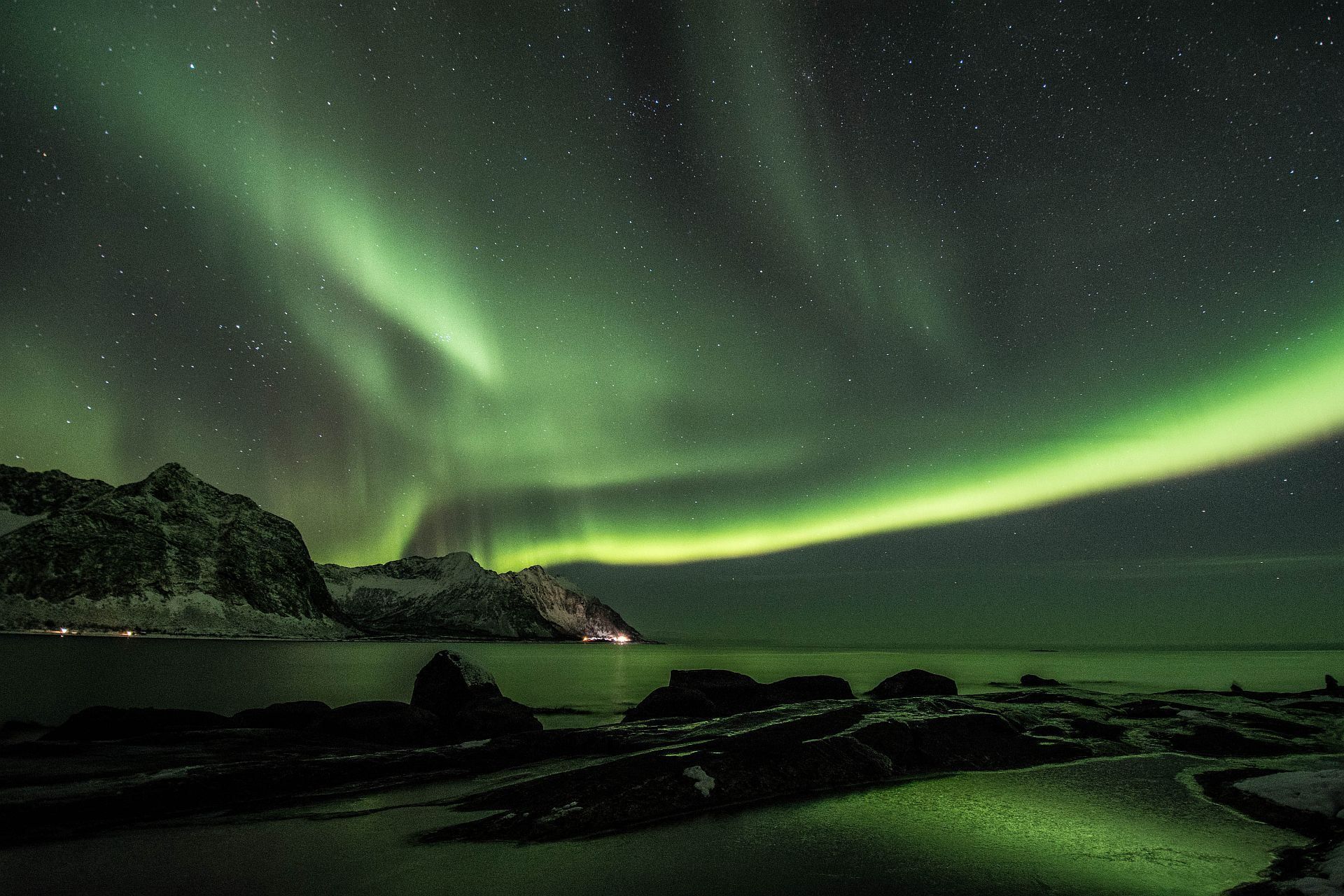 Northern Lights above the sea and mountains on Senja.