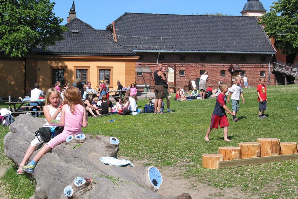 A house and lots of people on a lawn.