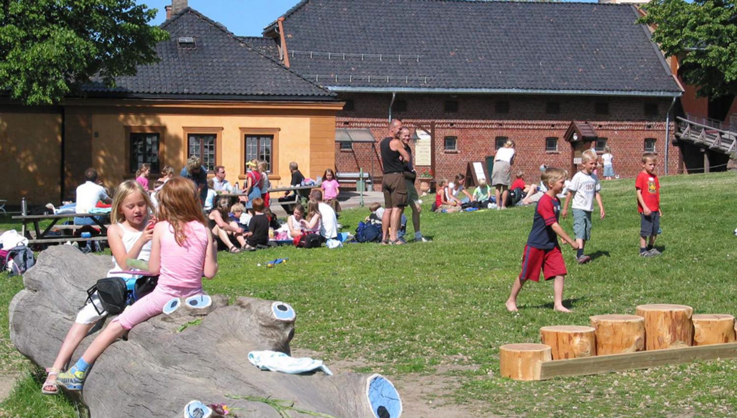 A house and lots of people on a lawn.