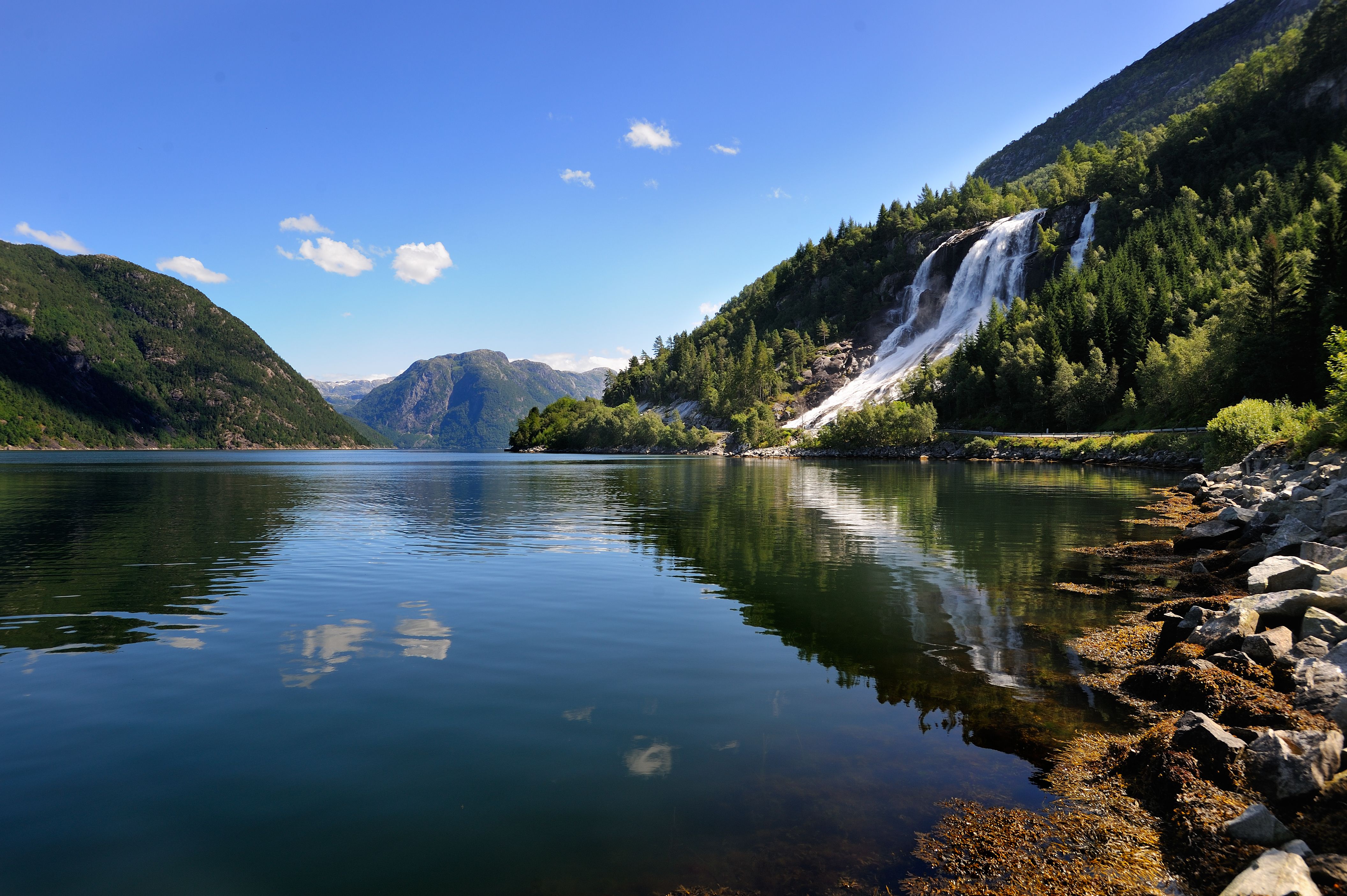 Reflection of Furubergsfossen – Furubergsfossen mirrored in a calm fjord on a beautiful summer day in Hardanger.