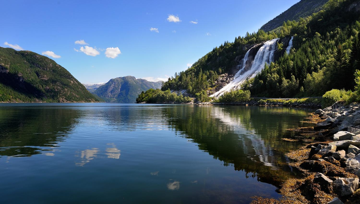 Reflection of Furubergsfossen – Furubergsfossen mirrored in a calm fjord on a beautiful summer day in Hardanger.