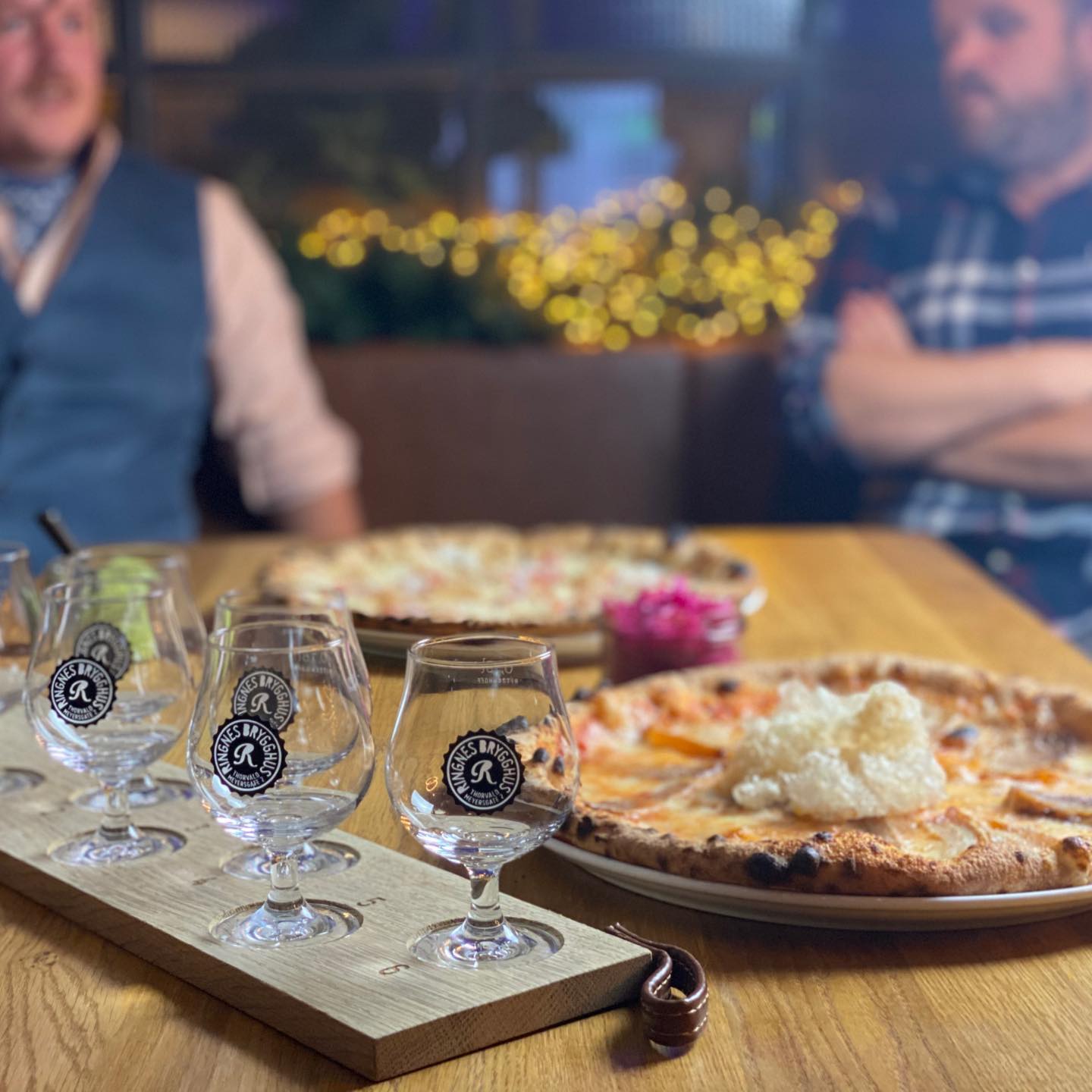 Detalj av pizzaer og tomme ølglass.
