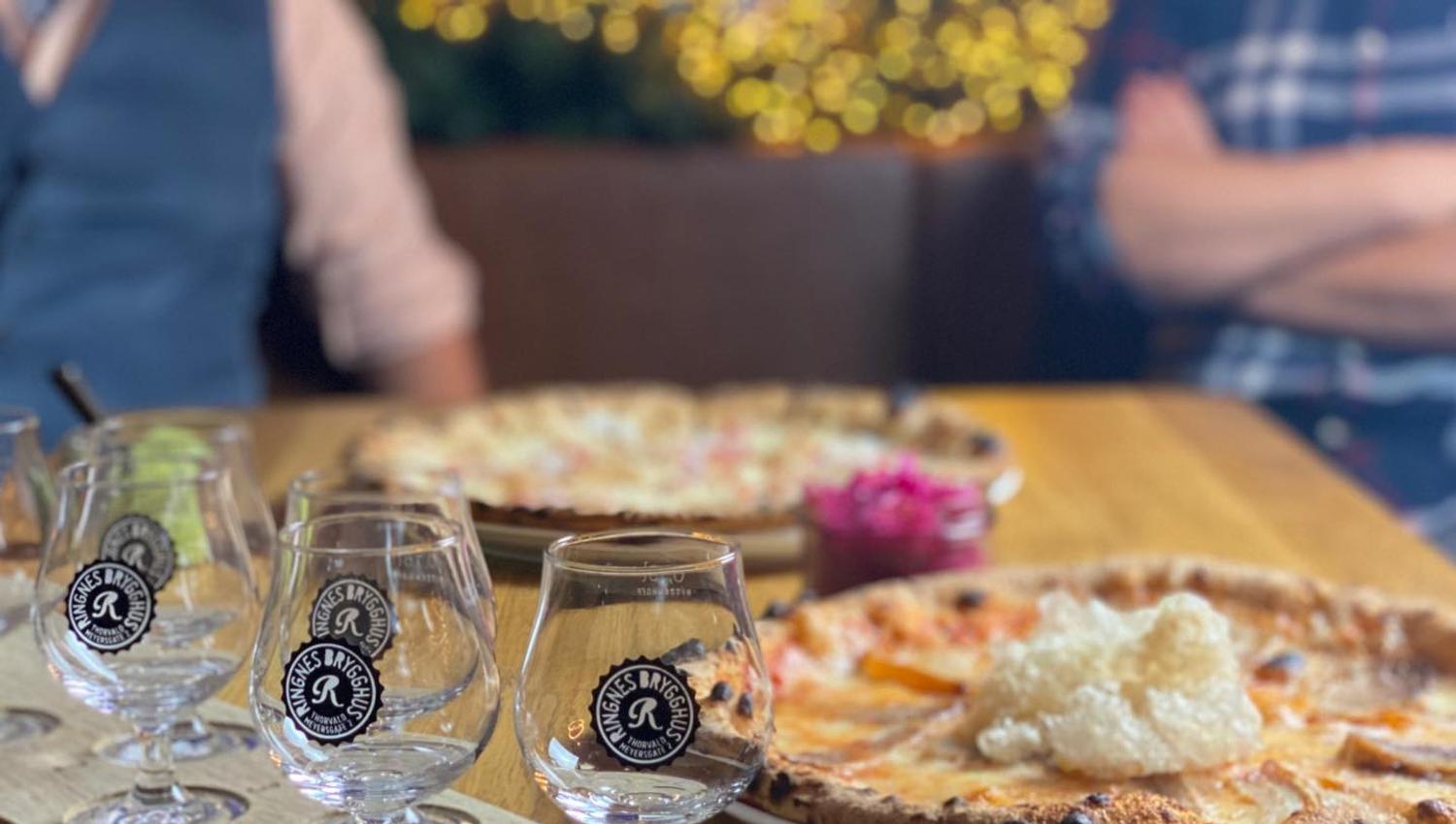 Detalj av pizzaer og tomme ølglass.