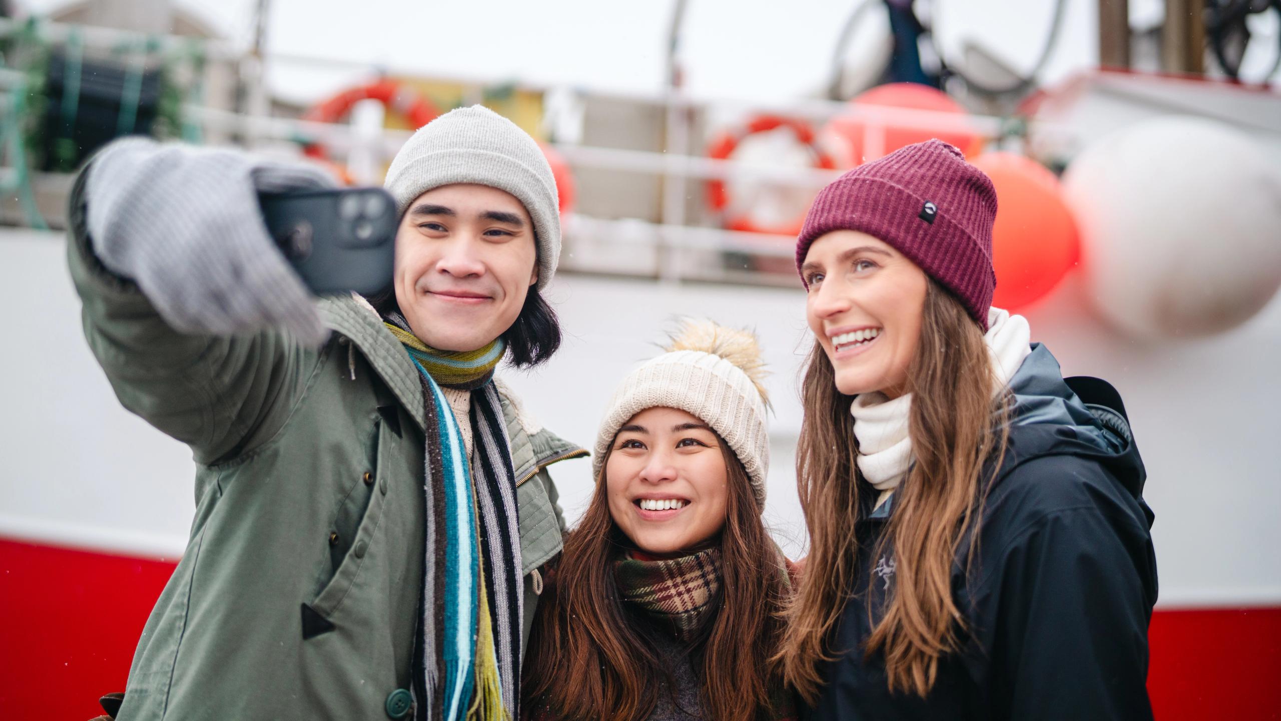 Two tourists taking a selfie with a local.