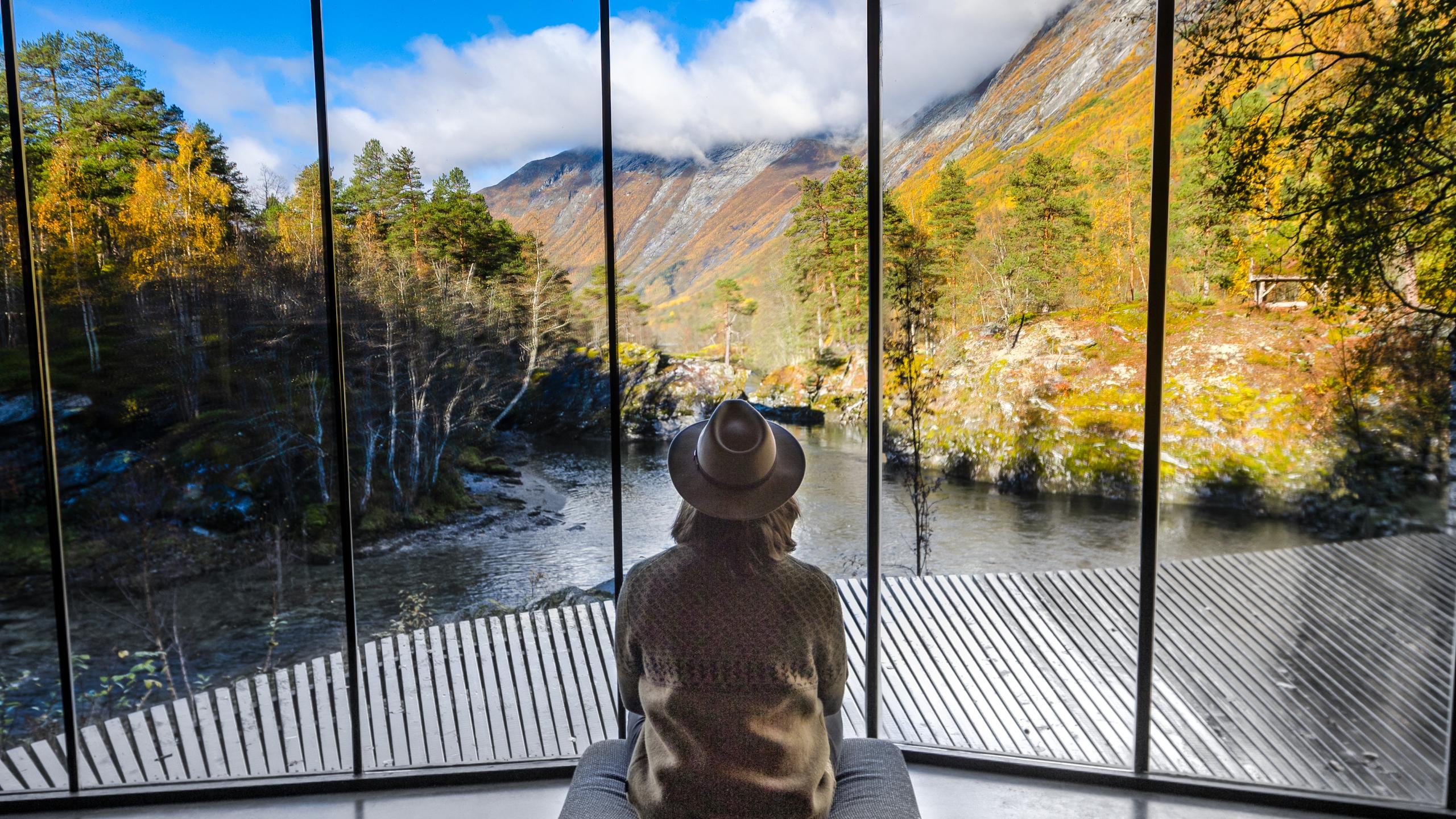 A woman looking at the view from Juvet Landscape Hotel in Valldal in Fjord Norway.