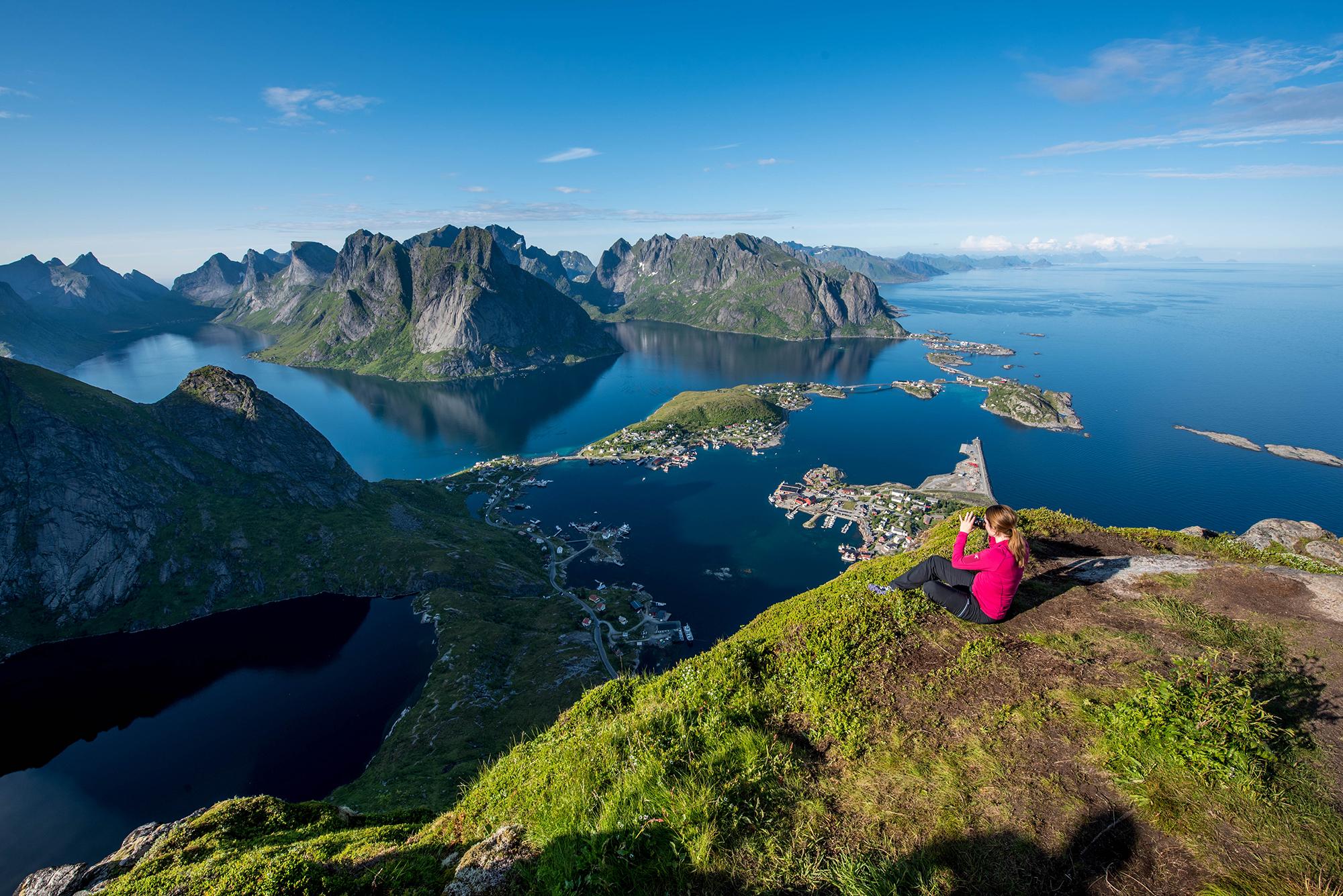 Dame på toppen av Reinebringen i Lofoten i Nord-Norge