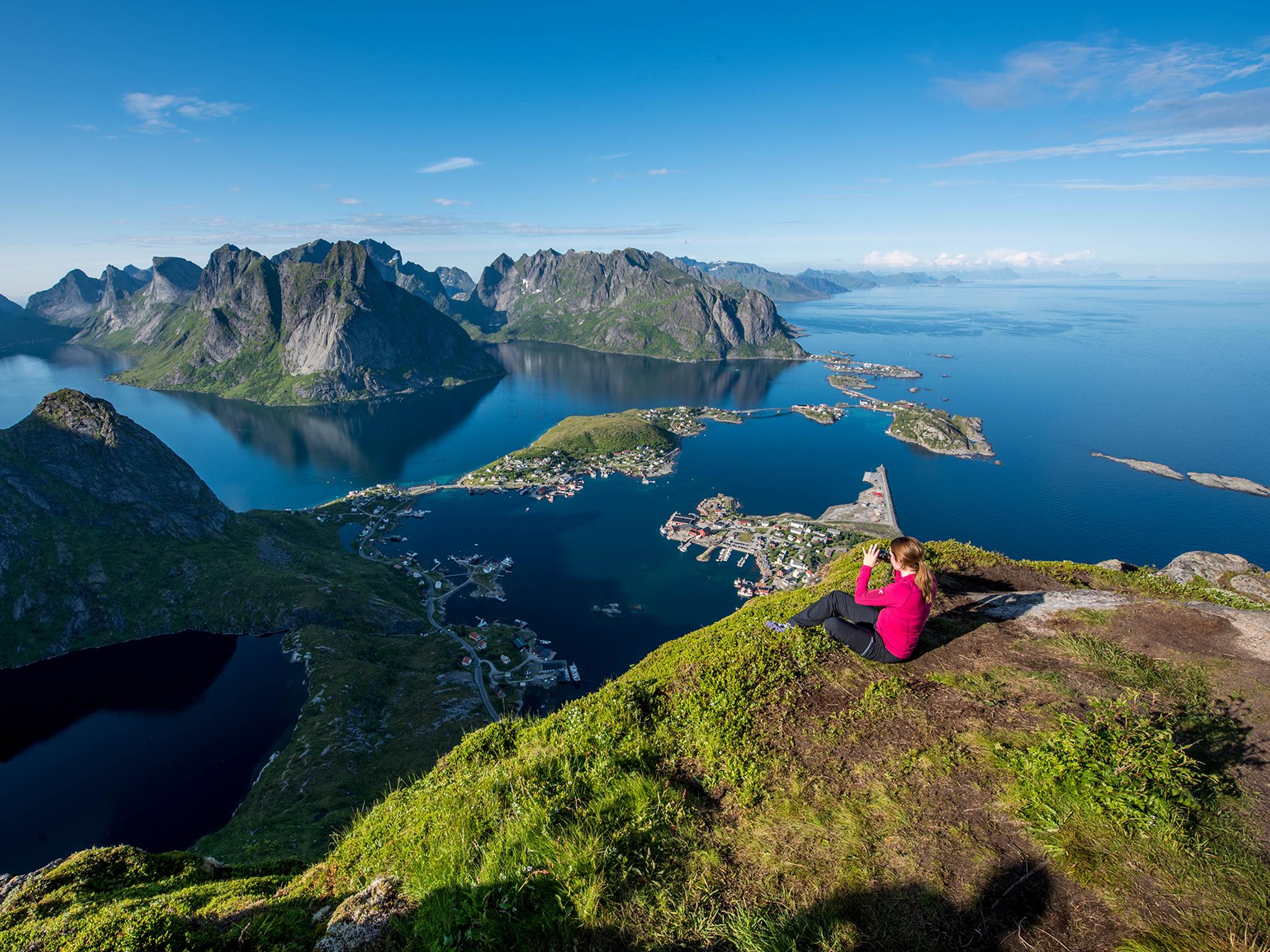 Dame på toppen av Reinebringen i Lofoten i Nord-Norge