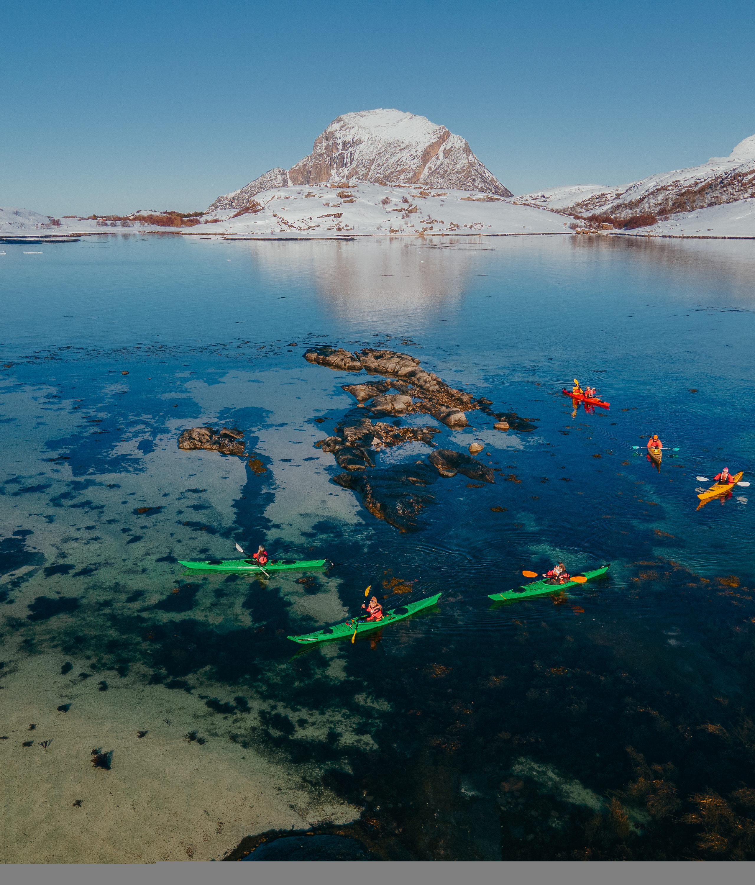 People kayaking in winter landscape.